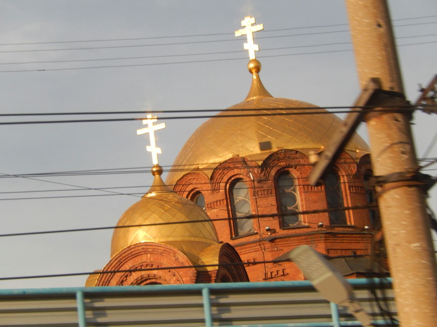 The train passes a beautiful church glowing in the dawn light.