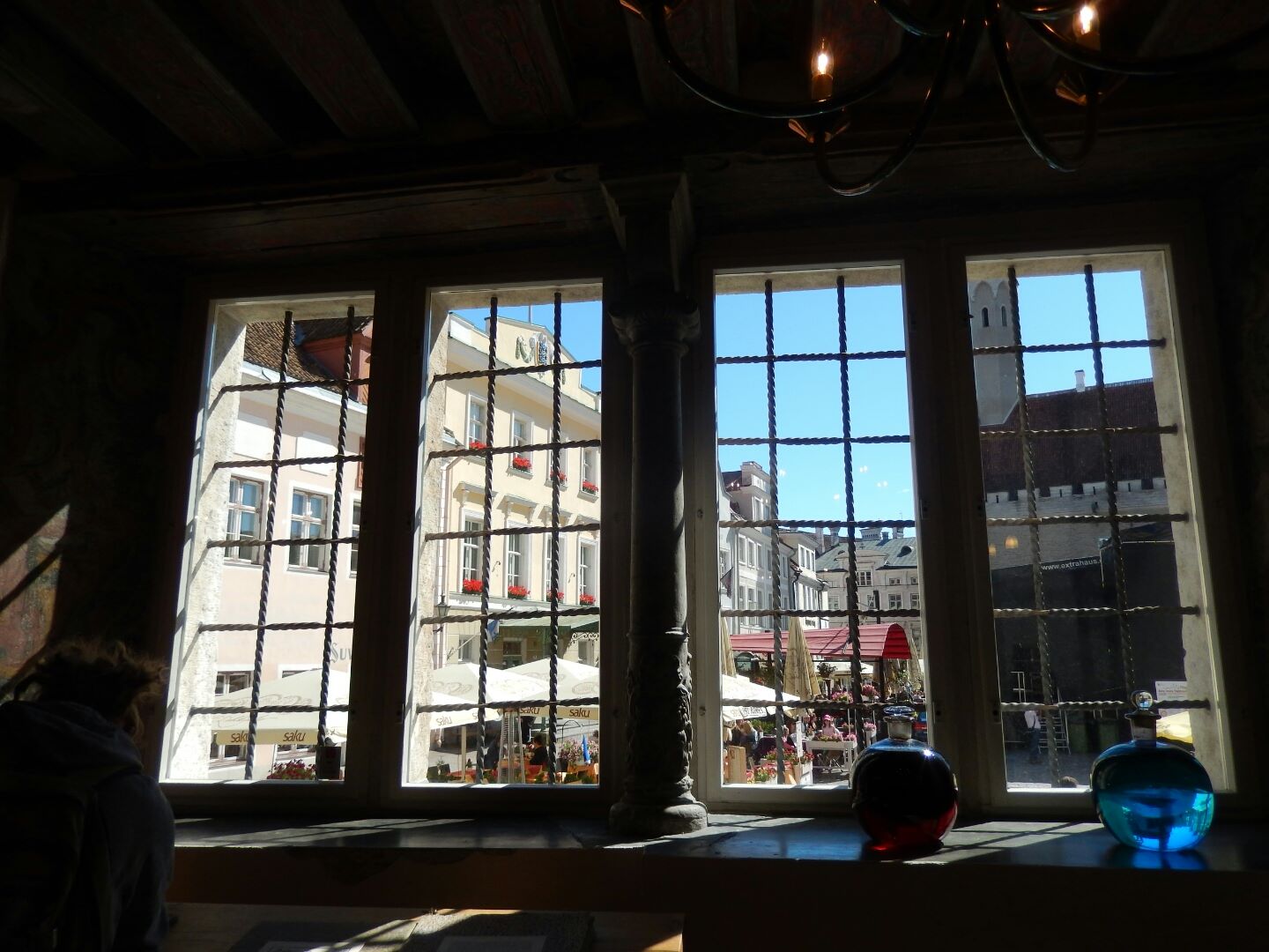 Inside the pharmacy, looking out through the mullioned windows at the town square.
