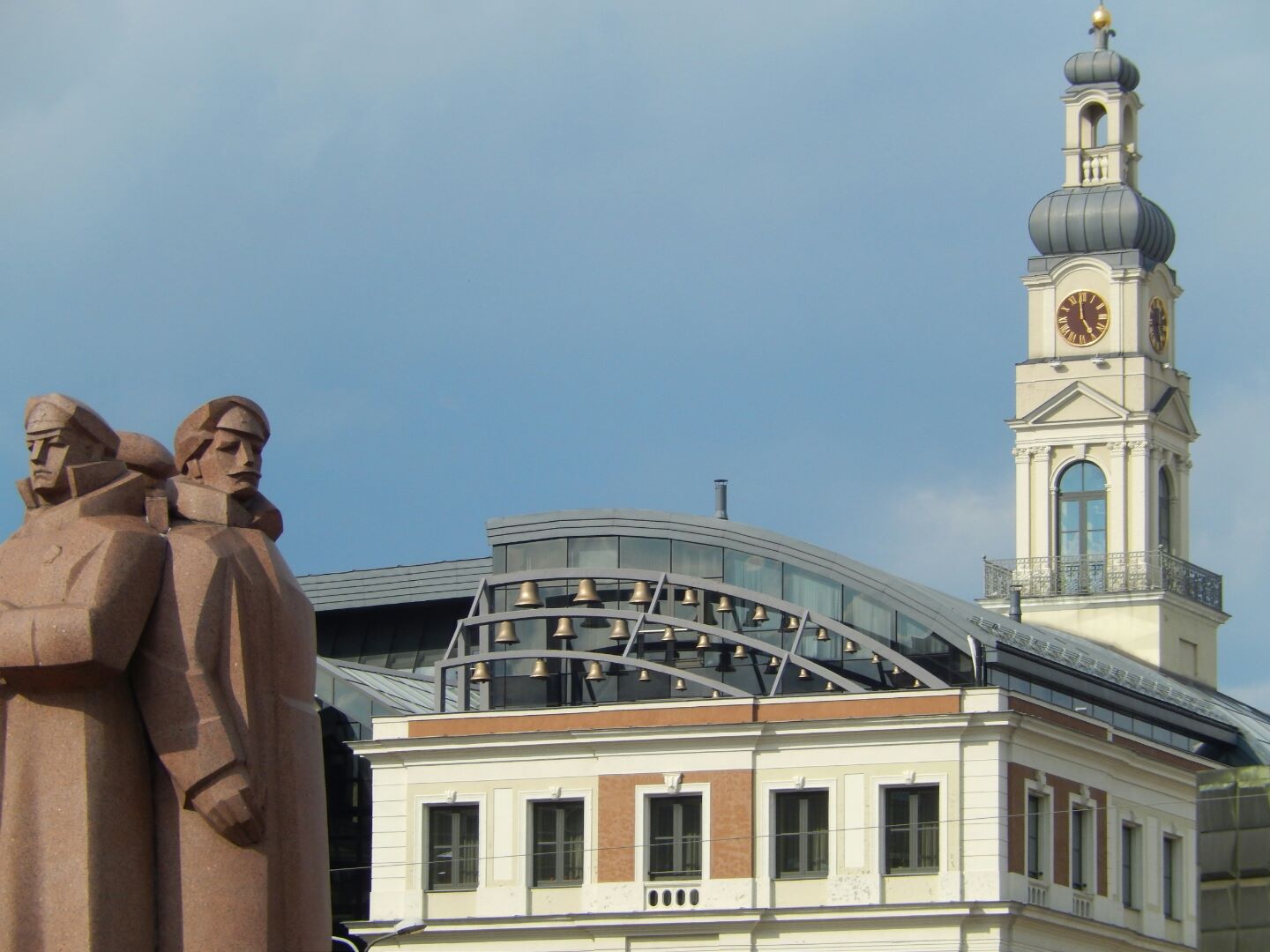 The bells in the forground were originally cast in the 13th century, but were remounted on the roof of the Riga Town Hall building in the late 20th century. The modern carillon forms a striking contrast to the Town Hall's 18th century clock tower.