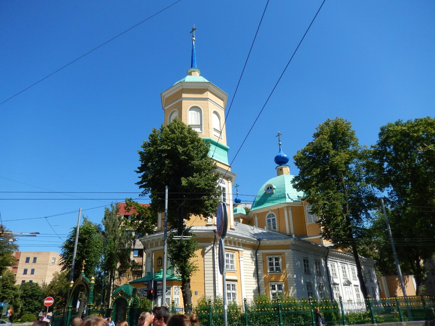 An unusual wooden church with blue steeple and onion dome.
